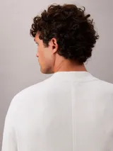 Sweater de punto técnico con corte boxy y cuello semi alto. Presenta un diseño minimalista de manga larga con puños en contraste y ajuste relajado.