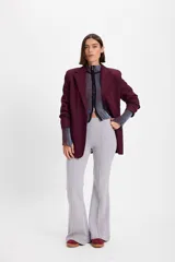 Pantalón de felpa gris con corte flare y terminación acampanada. Presenta una pretina elástica y detalle de costura vertical tipo alforza en el centro delantero.