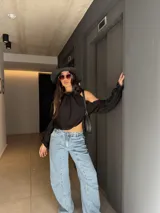 Blusa de manga larga y hombros descubiertos de color negro, con diseño halter fruncido en el cuello y mangas abullonadas caídas.