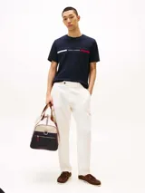 Remera azul marino de algodón con cuello redondo y logo de Tommy Hilfiger bordado en el pecho. El logo consiste en una franja blanca, el nombre de la marca y una franja roja.