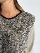 Chaleco de punto gris con diseño de trenzas.