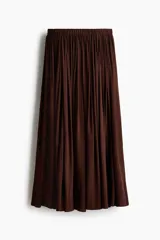 Pollera larga de modal en color marrón, de corte holgado, tiro alto con cintura elástica y diseño fruncido.