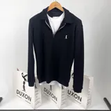 Sweater de punto negro con cuello polo, cierre de cremallera metálica y logo bordado en el pecho.