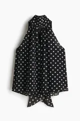 Top de corte holgado en tejido transparente con estampado de lunares, cuello alto estilo pañuelo y diseño sin mangas.