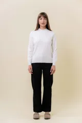 Buzo de punto fino color blanco, con cuello semi alto y manga larga.