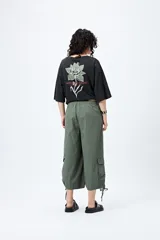 Bermuda gris de corte ancho con bolsillos cargo y tiras ajustables en el ruedo.