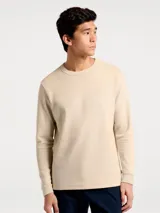 Camiseta térmica de manga larga con cuello redondo, confeccionada en tejido de punto tipo waffle en color beige.