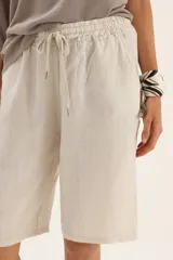 Bermuda larga color beige confeccionada en lino, con cordón ajustable en la cintura.