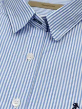 Camisa de vestir entallada a rayas verticales celestes y blancas, de manga larga y cuello clásico.