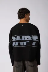 Buzo oversize de corte boxy, confeccionado en algodón rústico de alto gramaje en color beige. Presenta cuello redondo con borde crudo, mangas largas y una estampa frontal con el texto VCP delimitado por líneas horizontales blancas.