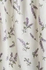 Vestido corto blanco con estampado floral en tonos lavanda, escote cuadrado con volantes, mangas cortas abullonadas con volantes y cuerpo fruncido.
