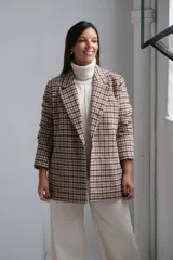 Blazer de corte recto con estampado a cuadros en tonos beige y marrón, con solapas clásicas y cierre frontal.