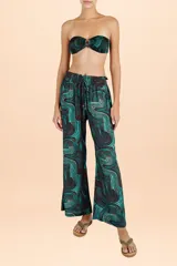 Pantalón palazzo de tiro alto con cintura elástica y cordón ajustable. Presenta un diseño de pierna ancha y fluida con un estampado geométrico de ondas en tonos turquesa y marrón.