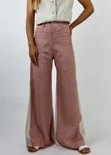 Pantalón de lino color marrón con paneles laterales en color crema y corte acampanado.