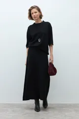 Falda midi tejida de corte recto y silueta fluida, con diseño minimalista y abertura lateral.