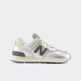 Championes New Balance modelo 574, con capellada de material sintético metalizado color plateado, detalles en beige claro y logo 'N' en gris oscuro. Cuentan con entresuela ENCAP para amortiguación.
