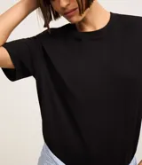 Blusa básica lisa de algodón color negro, con cuello redondo y mangas cortas, de corte clásico y versátil.