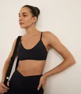 Top deportivo negro, tipo bralette, con escote en V y tirantes finos ajustables.