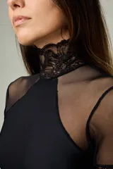 Body entallado de lycra color negro con cuello alto, mangas cortas y detalles en microtul y encaje.
