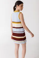 Vestido corto tejido de punto a rayas horizontales en tonos celeste, crema, marrón y mostaza. Tiene cuello alto y cierre metálico frontal. Sin mangas.