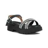 Sandalias de plataforma negra con suela dentada, tiras cruzadas en el empeine cubiertas de strass plateado y pulsera al tobillo con hebilla metálica.