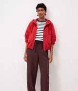 Pantalón carrot marrón de tiro alto, confeccionado en mezcla de viscosa y poliéster, con cintura elástica fruncida, cordón de ajuste tipo lazo con punteras metálicas, bolsillos y recortes estructurados en las piernas.