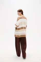 Saco de punto con diseño de rayas horizontales en negro, gris y blanco. Presenta cuello en V, cierre frontal con botones y bolsillos laterales.