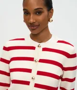 Cardigan de punto con diseño rayado horizontal en color blanco y rojo. Presenta escote redondo, manga larga, cierre frontal con botones dorados y bolsillos delanteros discretos. Posee una caída estructurada y acabado sofisticado.