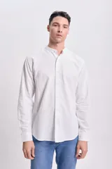 Camisa blanca de manga larga con cuello mao y cierre frontal con botones.