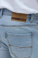 Jean slim fit de color celeste claro, con tiro medio y diseño clásico de cinco bolsillos.
