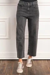 Pantalón de jean negro con efecto gastado y pequeños brillos. Corte recto, tiro alto y terminación desflecada.