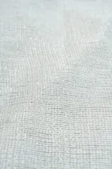 Poncho de tejido ligero con acabado brillante y flecos en los extremos.