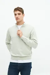 Buzo azul marino de tejido de punto con cuello alto y medio cierre con cremallera.