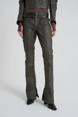 Pantalón de cuero color gris con tiro bajo, bolsillos delanteros con labio y cierre metálico oculto, pierna con recortes en delantero y pinza en espalda.