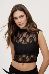 Top de encaje blanco con cuello alto y diseño sin mangas, de corte ajustado.