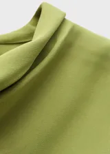 Vestido corto de color verde oliva, confeccionado en tejido fluido con cuello alto y mangas largas acampanadas. Presenta un diseño evasé que aporta movimiento a la prenda.