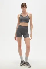Top deportivo de tejido sin costuras, color gris melange, con escote redondo y breteles finos tipo nadadora.