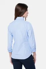 Camisa celeste a rayas verticales, de corte entallado y manga larga.