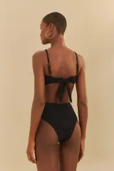 Bikini negro con corpiño bandeau con detalle de sol dorado y tirantes finos cruzados, y bombacha de tiro alto.