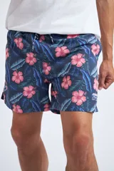 Short de baño con cintura elástica y cordón ajustable, confeccionado en tela ligera de secado rápido. Presenta un estampado botánico integral en tonos amarillos, blancos y azules, con dos bolsillos delanteros y uno posterior.