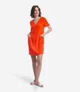 Vestido corto color naranja, de corte recto, con escote en pico y mangas cortas.