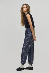 Pantalón sastrero de tiro alto con estampado de leopardo en tonos azulados, corte carrot, cintura ceñida con pliegues frontales, bolsillos laterales y bolsillo de ojal trasero.