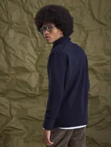 Cardigan de punto gris con cuello tipo chal y cierre frontal de botones. Presenta puños y ruedo acanalados, ofreciendo un diseño clásico y versátil.