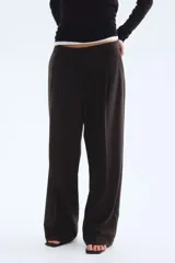 Pantalón amplio color negro, de corte holgado con pinzas, cierre con botón y corchetes ocultos, bolsillos laterales y piernas con pliegues adelante y atrás.