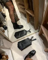 Bota de cuero negra con caña alta y estribo desmontable.