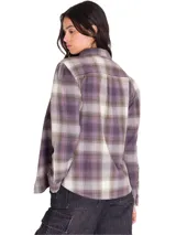Camisa de manga larga de franela con estampado a cuadros en tonos violeta, gris y blanco, de corte relajado, con bolsillos en el pecho y cierre frontal de botones.