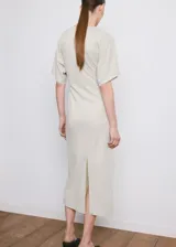 Vestido midi color beige claro, de corte recto, con cuello redondo, mangas cortas holgadas y detalle fruncido en el lateral de la cintura.