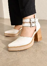 Zapatos de tacón alto color blanco con plataforma y punta fina, diseño destalonado y doble tira ajustable en el tobillo con hebillas metálicas.