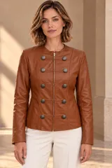 Campera de cuero ovino color beige, estilo napoleón, con cuello redondo, cierre frontal y botones metálicos decorativos en formato militar.