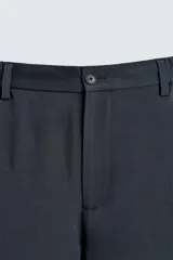 Pantalón de corte relaxed fit, con cintura ajustable, bolsillos delanteros y bolsillo trasero de plastrón. Presenta cierre frontal con cremallera y botón.
